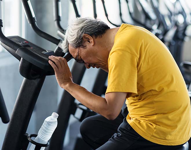 elderly man dizzy on exercise bike